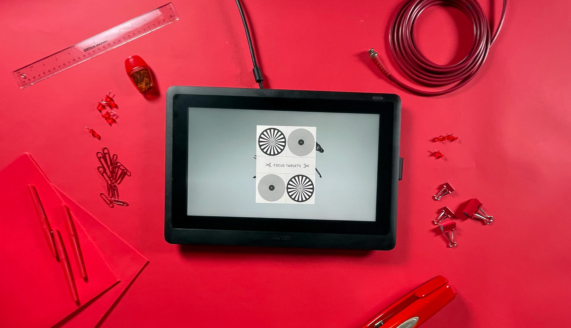 An Adobe product on top of a red table surrounded by red office supplies.