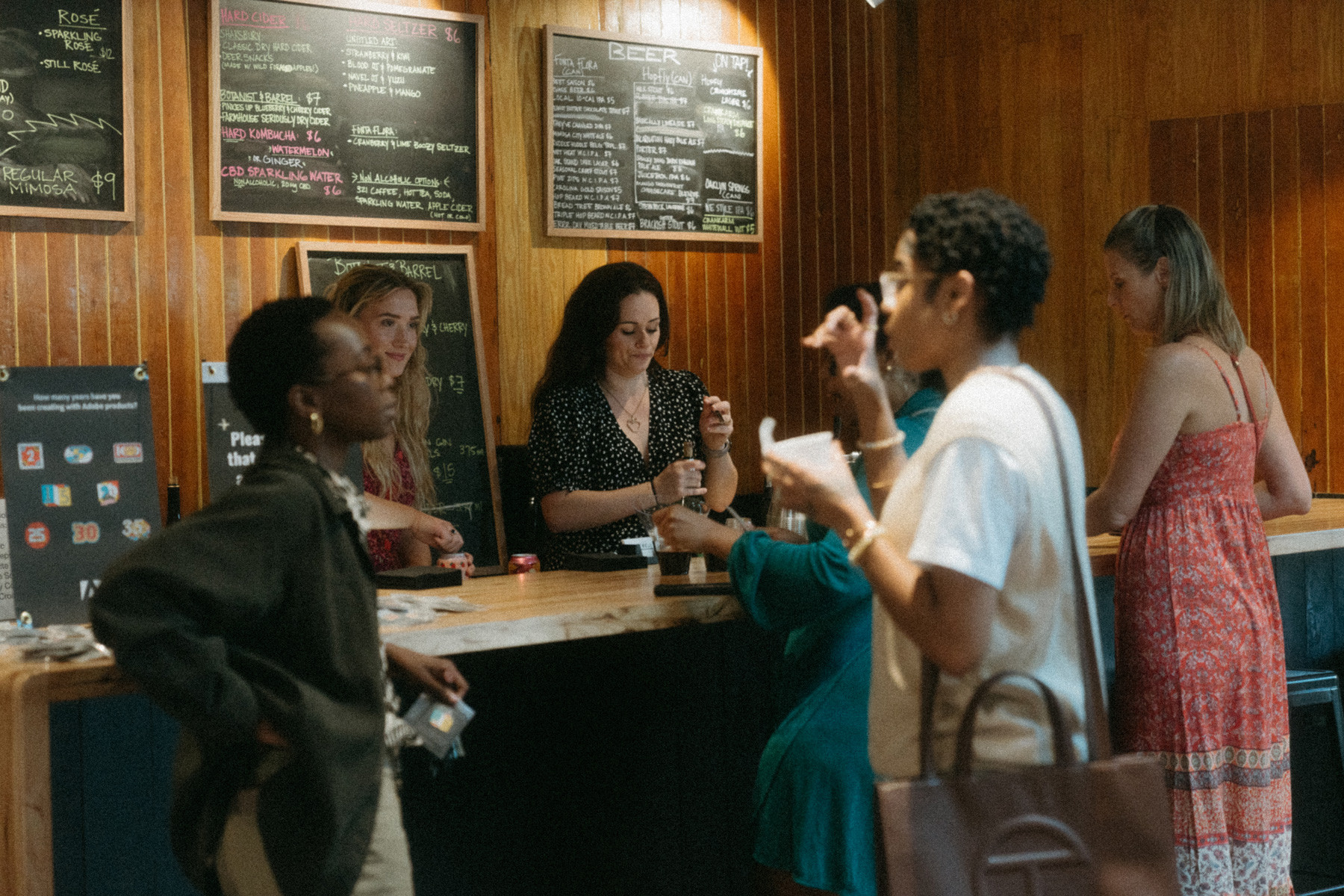 A group of women talking in front of a bar.