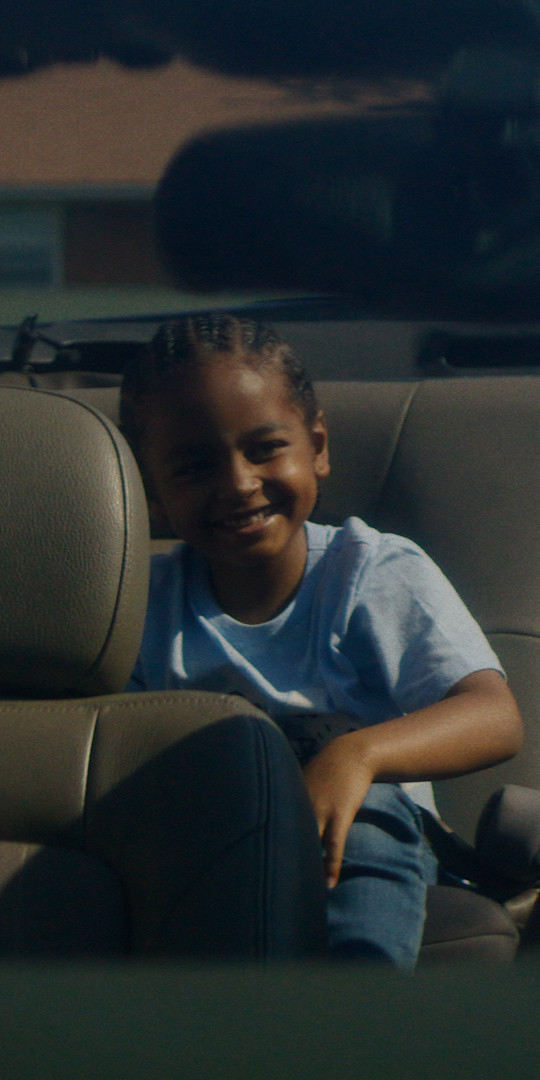 Boy rides in the backseat of a car